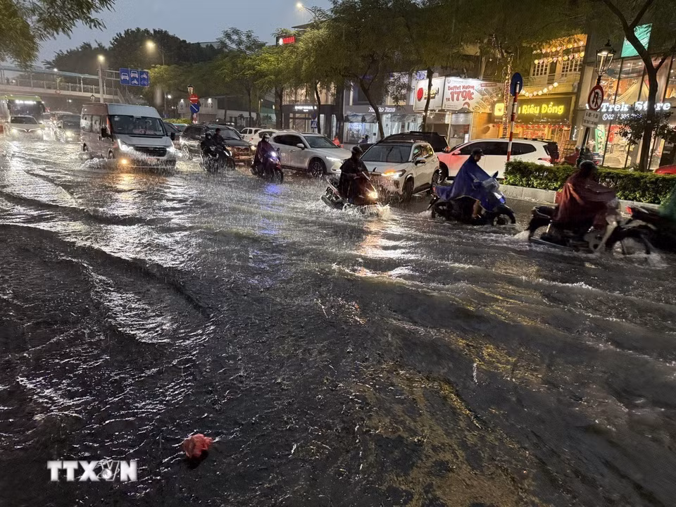 Giao thông hỗn loạn do mưa lớn và nước ngập trên đường Nguyễn Văn Cừ. (Ảnh: An Đăng/TTXVN)