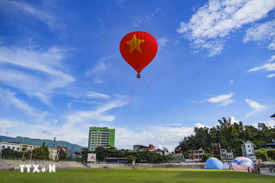 Khinh khí cầu mang Quốc kỳ Việt Nam bay trên sân vận động tại phường Điện Biên Phủ, thu hút sự quan tâm của người dân và du khách. (Ảnh: Xuân Tư/TTXVN)