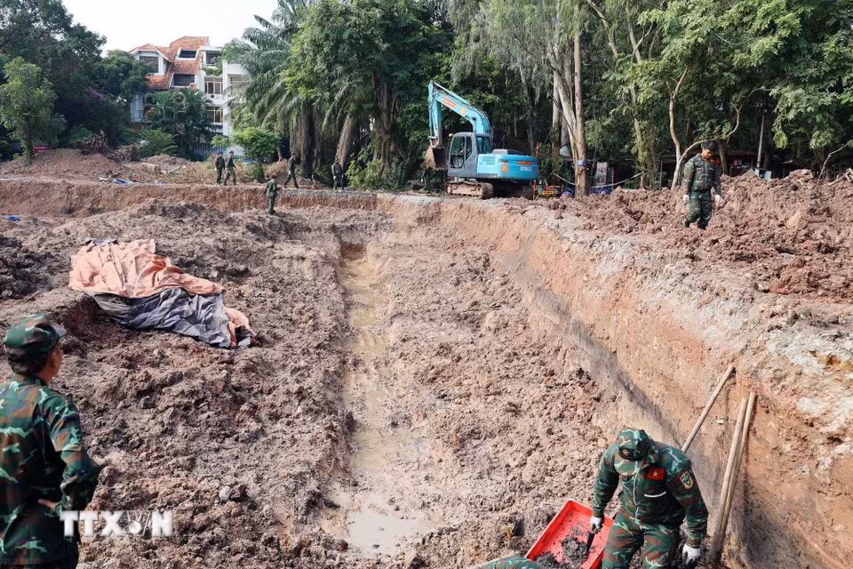 Lực lượng chức năng tiếp tục mở rộng diện tích khai quật tại khu B, công viên Lê Thị Riêng. (Ảnh: Xuân Khu/TTXVN)