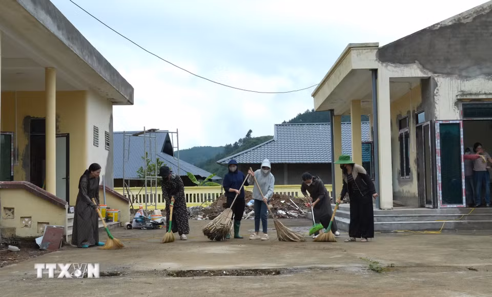 Các cô giáo cặm cụi dọn trường lớp, cùng chung quyết tâm “cho những bước chân trẻ thơ trở lại trường”. (Ảnh: Việt Dũng/TTXVN)