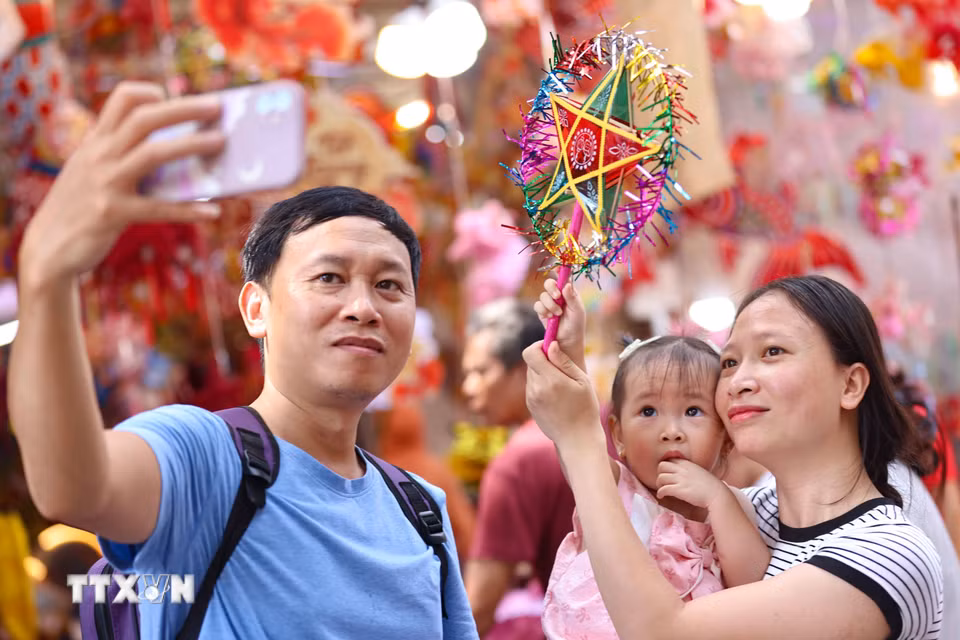 Lưu lại khoảnh khắc đẹp trong không khí rực rỡ sắc màu của chợ Trung Thu truyền thống. (Ảnh: Thanh Tùng/TTXVN)