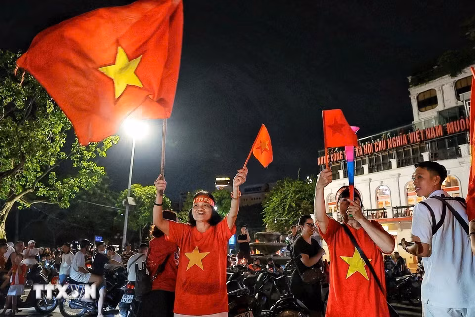 Người dân đổ ra đường ăn mừng chiến thắng của đội tuyển Việt Nam. (Ảnh: Phạm Tuấn Anh/TTXVN)