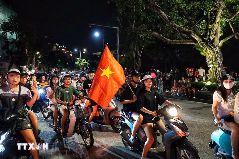 Người dân đổ ra đường ăn mừng chiến thắng của đội tuyển Việt Nam. (Ảnh: Phạm Tuấn Anh/TTXVN)