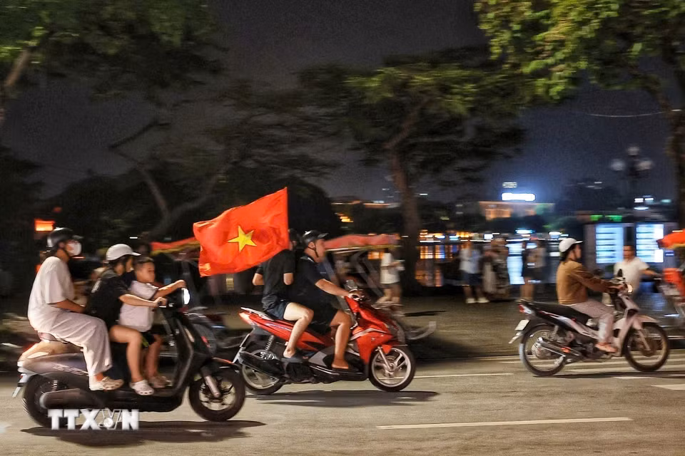 Màu đỏ của lá cờ Tổ quốc tô thắm mọi nẻo đường trong đêm chiến thắng của đội tuyển Việt Nam. (Ảnh: Phạm Tuấn Anh/TTXVN)