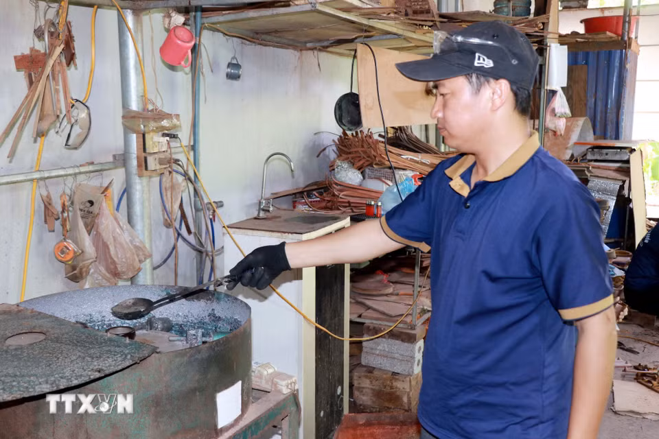 Anh Trần Văn Điệp, xã Cát Thành (Ninh Bình) đổ chì tạo các sản phẩm trang trí thuyền buồm. (Ảnh: Nguyễn Lành/TTXVN)
