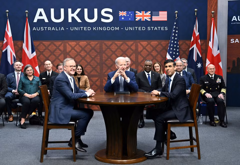 Ngày 13/3/2023, Thủ tướng Anh Rishi Sunak (phải, phía trước) cùng Tổng thống Mỹ Joe Biden (giữa) và Thủ tướng Australia Anthony Albanese (trái, phía trước) đã chính thức ra mắt thỏa thuận tàu ngầm hạt nhân AUKUS - "quan hệ đối tác quốc phòng đa phương quan trọng nhất trong nhiều thế hệ." Tuyên bố chung của các nhà lãnh đạo nêu rõ trong dự án nhiều giai đoạn này, năng lực chế tạo của Anh và Australia được phát huy tối đa để tạo ra một tàu ngầm lớp mới, SSN-AUKUS, dựa trên thiết kế tàu thế hệ tiếp theo của Anh, được đóng tại Anh và Australia kết hợp với công nghệ tiên tiến của Mỹ. (Ảnh: AFP/TTXVN)
