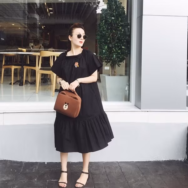 Cũng chọn đầm đen dáng suông, Yến Nhi mix đầm với sandals và túi xách có thiết kế xinh xắn, lôi cuốn bởi vẻ nữ tính pha lẫn nét nghịch ngợm.
