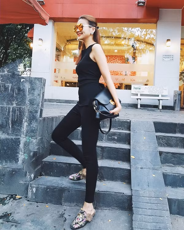 Dẫn đầu trào lưu mix đồ tuyền đen trong tuần qua, Thanh Hằng khai thác triệt để lợi thế vóc dáng chuẩn cùng cặp đôi quần skinny và áo sát nách. Ngoài túi xách được phối màu đồng điệu, nàng host của chương trình Vietnam's Next Top Model 2016 còn nâng cấp vẻ thời thượng cho bộ đồ bằng đôi giày xỏ đính lông, in họa tiết bắt mắt từ nhà mốt Gucci. 
