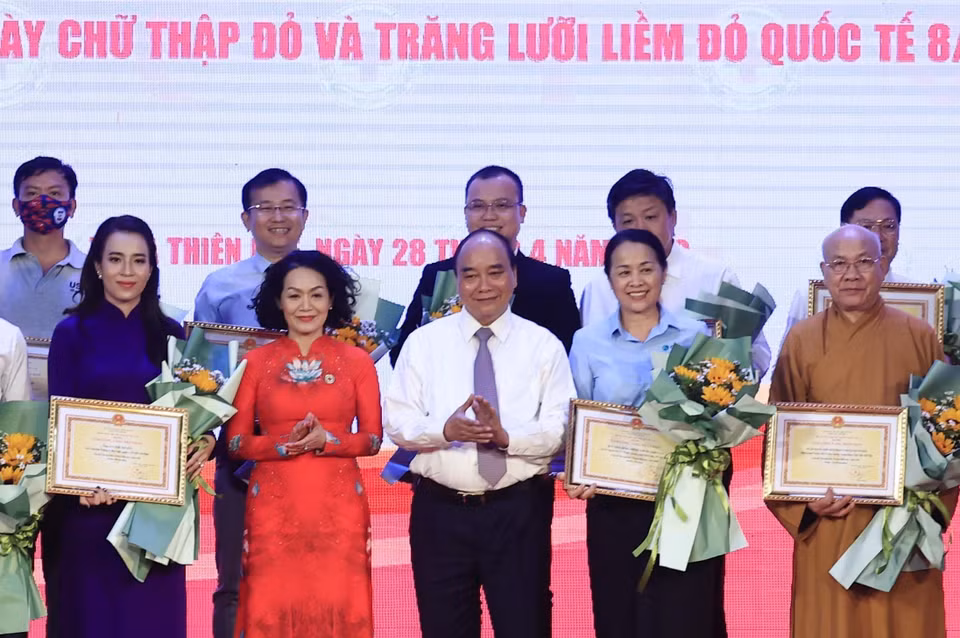 Chủ tịch nước Nguyễn Xuân Phúc tặng hoa, tri ân các nhà tài trợ. (Ảnh: Thống Nhất/TTXVN)