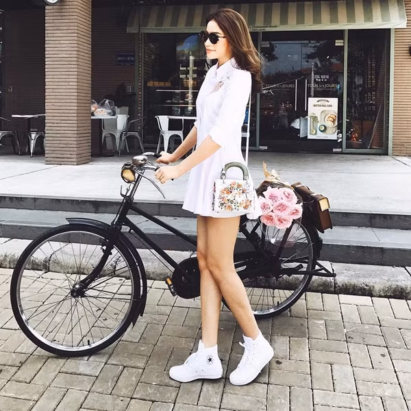 Ngày đẹp trời, Phạm Hương xuống phố với đầm sơmi màu trắng, kết hợp giày thể thao khỏe khoắn và túi đeo nhỏ tiệp màu của Dior.