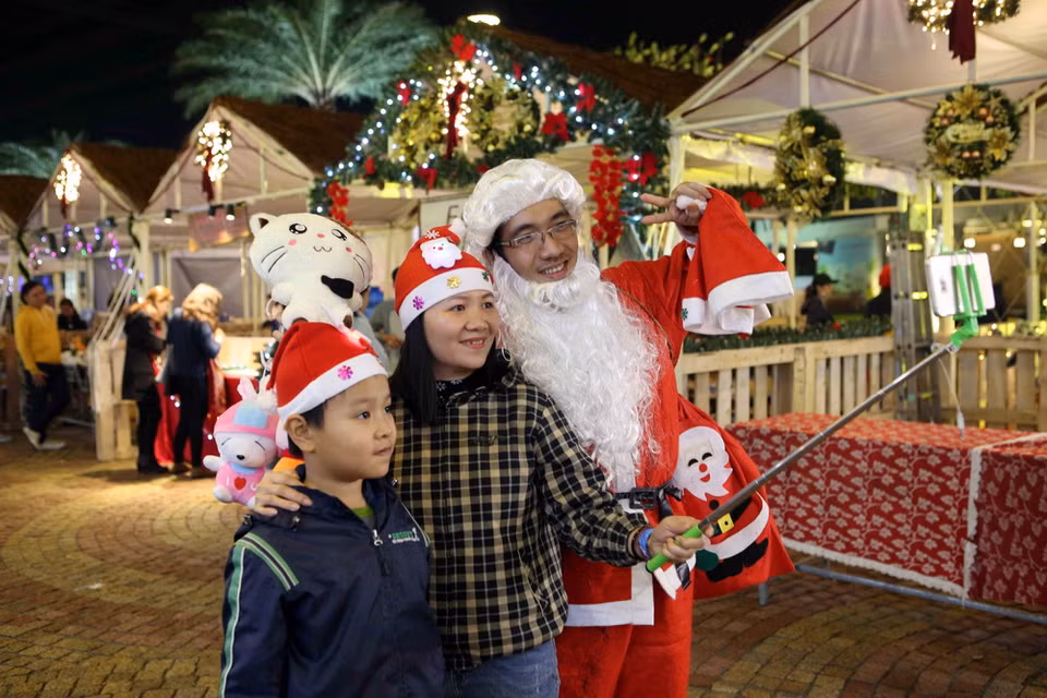 Tranh thủ chụp ảnh tự sướng cùng ông già Noel. (Ảnh: Trần Lê Lâm/Vietnam+)