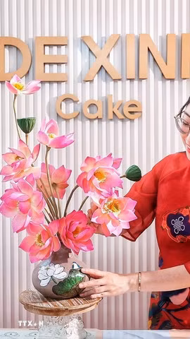 Sản phẩm hoàn thiện là sự kết hợp giữa hai kỹ thuật tạo hình: phần bình được làm từ bánh Trung Thu, trong khi những cành sen phía trên được nặn thủ công từ bột tò he. Sự kết hợp này tạo cho chiếc bánh Trung thu dáng vẻ như một bình hoa nghệ thuật. (Ảnh: Phạm Tuấn Anh/TTXVN)