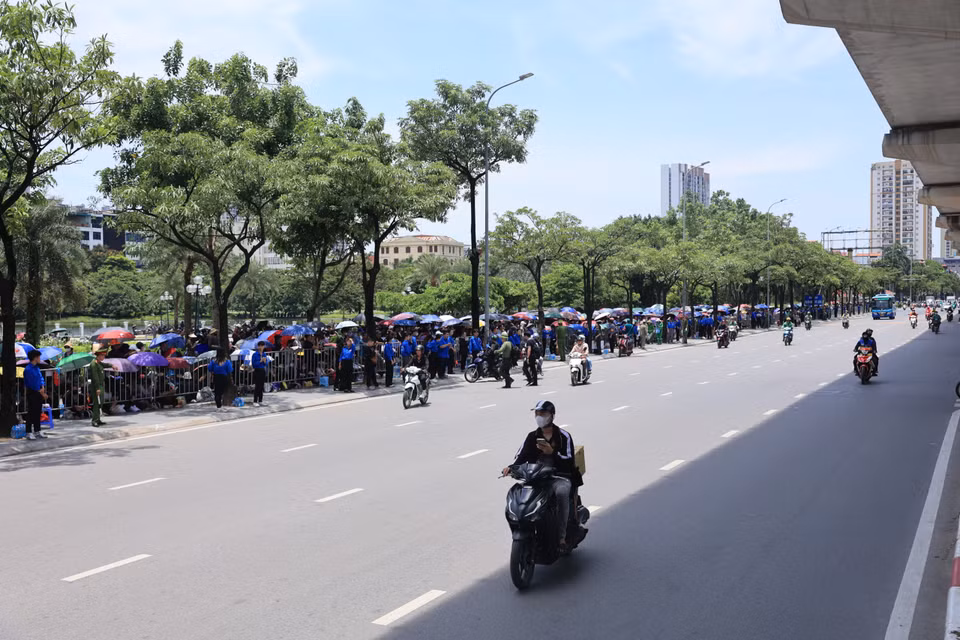 Hàng dài người dân xếp hàng đối diện dọc đường Hồ Tùng Mậu đến ngã tư Hồ Tùng Mậu-Nguyễn Cơ Thạch. (Ảnh: Hoài Nam/Vietnam+)