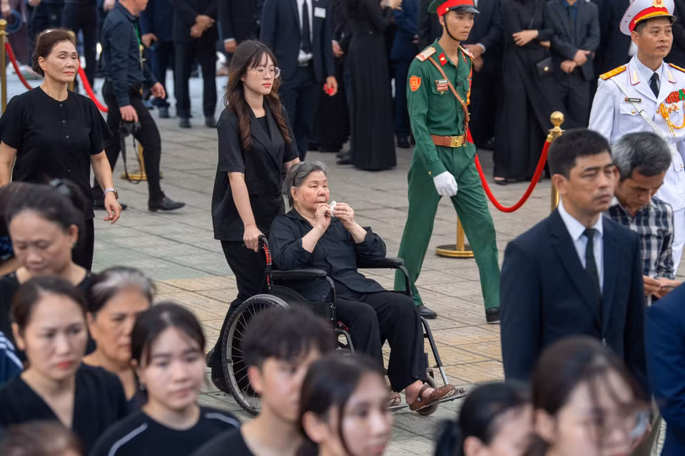 Cô giáo Đặng Thị Phúc (người ngồi xe lăn), người đã dạy Tổng Bí thư Nguyễn Phú Trọng năm lớp 4 đến viếng học trò. (Ảnh: Minh Sơn/Vietnam+)