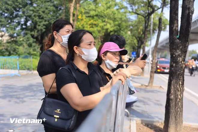 Càng về trưa, trời càng nắng nóng nhưng đoàn người vẫn trật tự, nghiêm trang xếp hàng khu vực rào chắn. (Ảnh: Hoài Nam/Vietnam+)