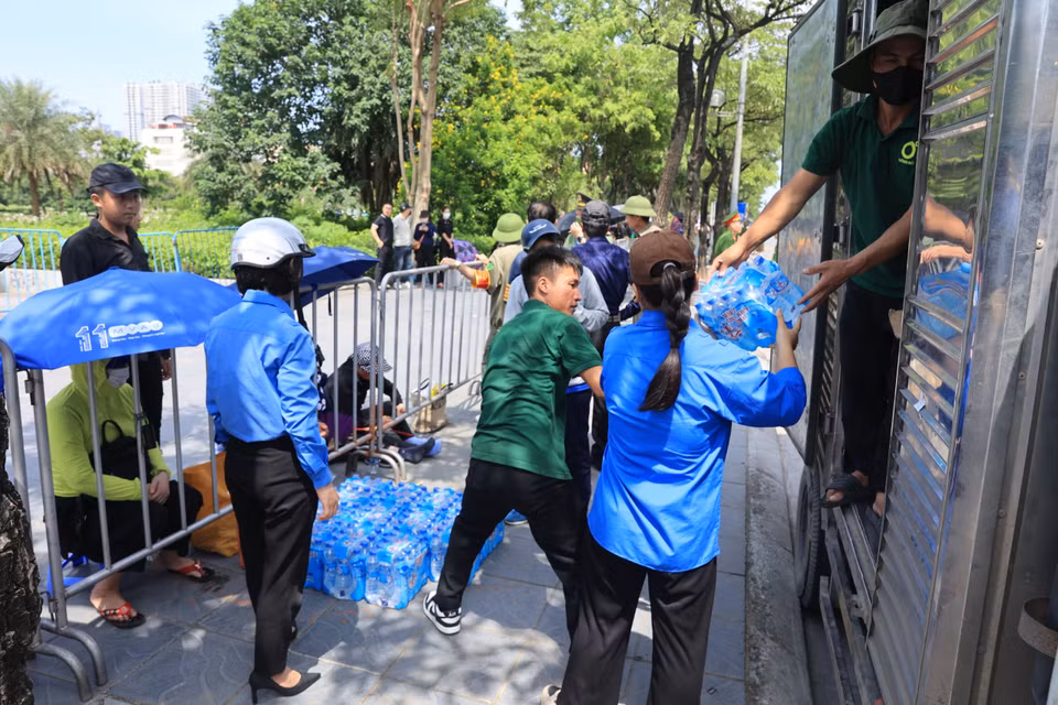Các thanh niên tình nguyện vận chuyển nước uống để phục vụ người dân. (Ảnh: Hoài Nam/Vietnam+)