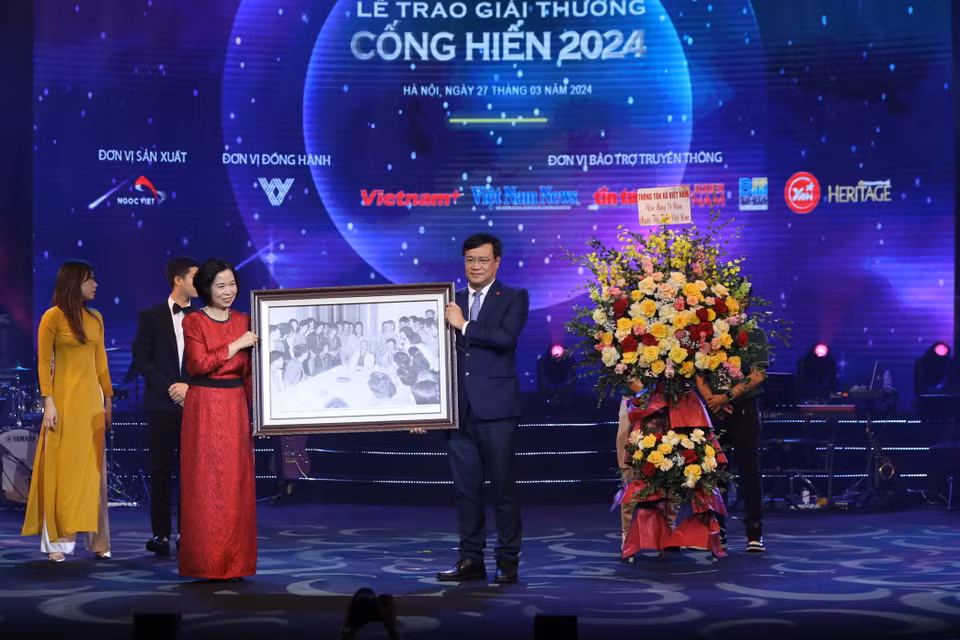 Giải thưởng năm nay diễn ra đúng Ngày Thể thao Việt Nam (27/3) và đã bắt đầu với cụm giải thưởng cho mảng Thể thao. Trong ảnh Tổng Giám đốc Thông tấn xã Việt Nam Vũ Việt Trang trao bức ảnh lưu niệm Bác Hồ gặp mặt các vận động viên xuất sắc năm 1966 cho ông Đặng Hà Việt - Cục trưởng Cục Thể dục Thể thao. (Ảnh: Hoài Nam/Vietnam+)