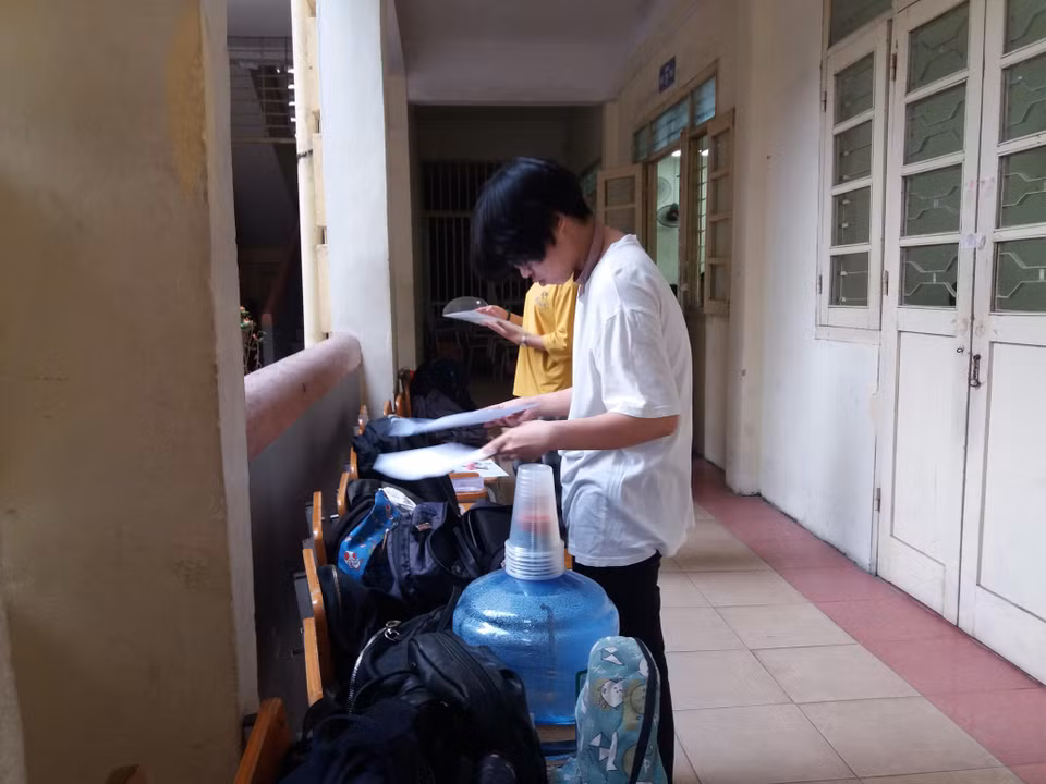 Thí sinh chuẩn bị các vật dụng để mang vào phòng thi. (Ảnh: PM/Vietnam+)