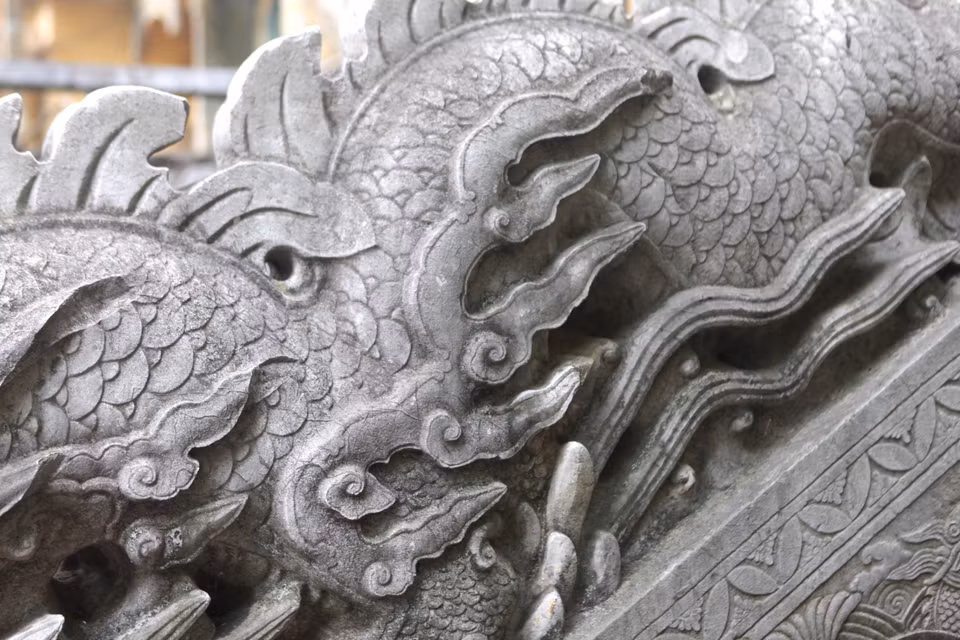 Nếu như rồng thời Lý mang sự nhẹ nhàng, mỏng manh, giống như đang uốn lượn trong mây, rồng thời Trần thể hiện sự mạnh mẽ với thân hình to lớn, khoẻ khoắn thì rồng trong hệ thống bộ thành bậc điện Kính Thiên phía Bắc thời Lê Trung Hưng lại được cách điệu hoa văn tinh xảo với dáng dấp cứng rắn. (Ảnh: PV/Vietnam+)