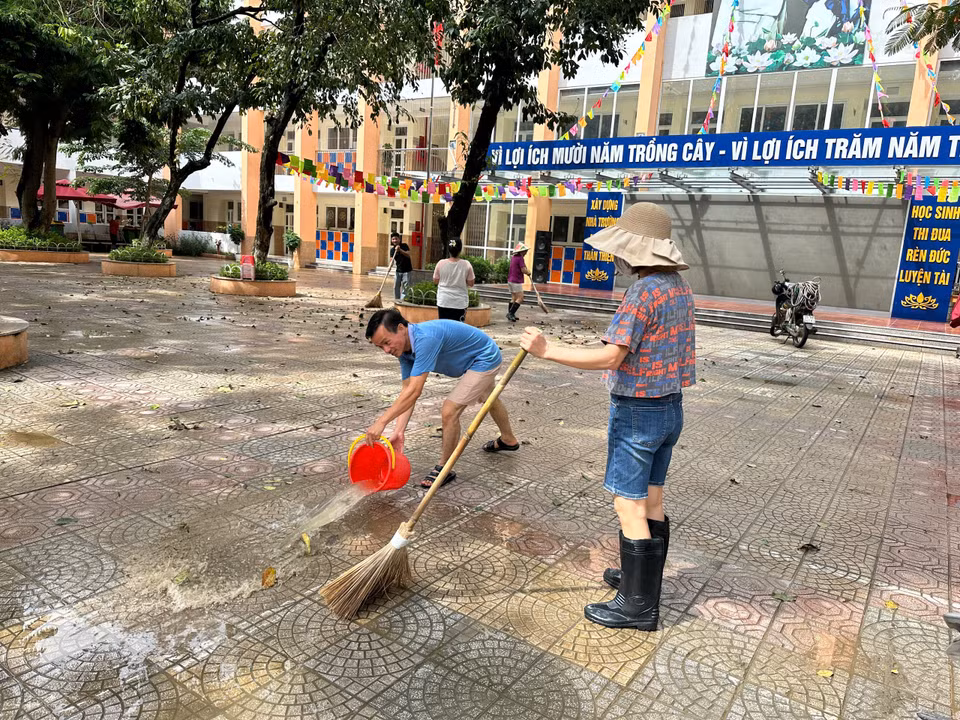 Hôm nay, 12/9, sau nhiều ngày liên tục có mưa lớn do ảnh hưởng của bão và hoàn lưu bão Yagi, Hà Nội đã cơ bản tạnh mưa và có thời điểm hểnh nắng. Các trường bị ngập lụt bởi mưa đã lập tức triển khai công tác vệ sinh môi trường để có thể đón học sinh đi học trở lại trong thời gian sớm nhất. Chiều nay, 12/9, sau khi nước rút khỏi sân trường, cán bộ, giáo viên, phụ huynh Trường Tiểu học Nghĩa Dũng đã cùng đến dọn dẹp, vệ sinh trường lớp. (Ảnh: PV/Vietnam+)