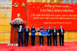 Bí thư Tỉnh ủy Vũ Đại Thắng và lãnh đạo tỉnh Quảng Ninh tặng hoa, tiền thưởng 350 triệu đồng cho cầu thủ Nguyễn Hai Long (từ nguồn ngân sách địa phương và xã hội hóa). (Ảnh: Thanh Tùng/TTXVN phát)