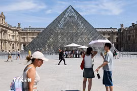 Du khách tham quan Bảo tàng Louvre ở Paris, Pháp dưới trời nắng gay gắt. (Ảnh: THX/TTXVN phát)