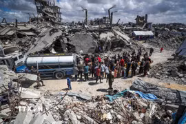 Người dân Palestine xếp hàng chờ lấy nước sinh hoạt tại trại tị nạn ở Dải Gaza ngày 10/4/2025. (Ảnh: THX/TTXVN)