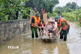 Lực lượng công an tỉnh Bắc Ninh hỗ trợ người dân di dời khỏi vùng lụt. (Ảnh: Danh Lam/TTXVN)