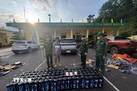 Đối tượng Tằng Dảu Thống (thứ 2 bên trái, sinh năm 1990, trú tại thôn Sông Móoc, xã Hoành Mô, tỉnh Quảng Ninh) cùng tang vật là 100 bình khí cười bị lực lượng chức năng bắt giữ. (Ảnh: TTXVN phát)