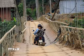 Tuy nhiên, do đây là cây cầu độc đạo nên hàng ngày học sinh vẫn chủ yếu đi về qua cầu treo này. (Ảnh: Anh Thùy/TTXVN)