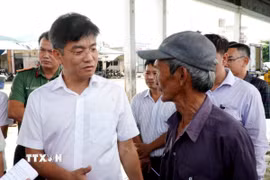 Phó chủ tịch UBND tỉnh Quảng Ngãi Đỗ Tâm Hiển (áo trắng) trao đổi với ngư dân phường Sa Huỳnh về công tác phòng, chống IUU. (Ảnh: Lê Phước Ngọc/TTXVN)