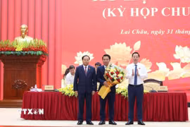 Ủy viên Trung ương Đảng, Bí thư Tỉnh ủy, Chủ tịch Hội đồng Nhân dân tỉnh Lai Châu Lê Minh Ngân và Chủ tịch Ủy ban Nhân dân tỉnh Lai Châu Hà Quang Trung tặng hoa chúc mừng ông Lý Công Hậu. (Ảnh: Việt Dũng/TTXVN)