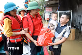 Bà Vũ Thị Quyên, Phó Chủ tịch Hội Chữ thập đỏ tỉnh Lạng Sơn trao quà cho hộ dân có nhà bị ngập tại xã Thất Khê, tỉnh Lạng Sơn. (Ảnh: Văn Đạt/TTXVN)
