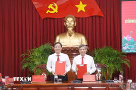 Ông Đồng Văn Thanh (phải), Ủy viên Ban Chấp hành Trung ương Đảng, Phó Bí thư Thường trực Thành ủy, Chủ tịch HĐND thành phố Cần Thơ và ông Trần Văn Huyến ký biên bản bàn giao công việc. (Ảnh: Ngọc Thiện/TTXVN)