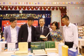 Đại sứ Việt Nam tại Lào Nguyễn Minh Tâm giới thiệu sách tại gian trưng bày của Việt Nam. (Ảnh: Xuân Tú/TTXVN)