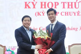 Đồng chí Dương Quốc Huy, Ủy viên Ban Chấp hành Trung ương Đảng, Bí thư Tỉnh ủy Lào Cai tặng hoa chúc mừng đồng chí Phan Trung Bá. (Ảnh: Tuấn Khôi/TTXVN)