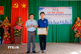 Trao tặng Giấy khen cho em Lê Đức Trung (17 tuổi), trú tại thôn Liêm Công Tây, xã Cửa Tùng vì có hành động dũng cảm cứu người bị đuối nước, hôm 28/6. (Ảnh: TTXVN phát)
