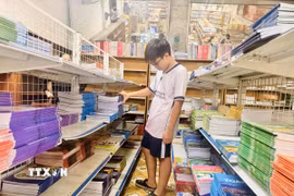 Học sinh tìm mua sách giáo khoa. (Ảnh: Hoàng Ngà/TTXVN)