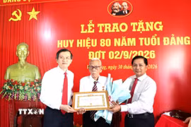 Đoàn công tác trao Huy hiệu 80 năm tuổi Đảng và hoa chúc mừng đảng viên Huỳnh Long Tòa, xã Cầu Ngang. (Ảnh: Thanh Hòa/TTXVN)
