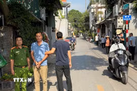 Đối tượng Tr.Q.H bị dẫn giải đến hiện trường vụ án. (Ảnh: TTXVN phát)