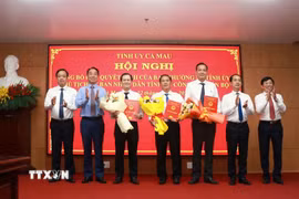 Lãnh đạo Tỉnh ủy, Ủy ban Nhân dân tỉnh trao quyết định của Chủ tịch UBND tỉnh và tặng hoa chúc mừng các đồng chí được điều động, bổ nhiệm. (Ảnh: Huỳnh Anh/TTXVN)