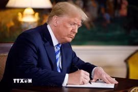 Tổng thống Mỹ Donald Trump ký sắc lệnh tại Nhà Trắng. (Ảnh: THX/TTXVN phát)