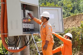 Cán bộ điện lực đóng điện trạm biến áp cung cấp điện cho cụm dân cư 3B. (Ảnh: Dư Toán/TTXVN)