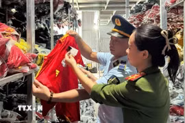 Một số lượng lớn quần áo mang nhãn hiệu NIKE, ADIDAS, PUMA bị lực lượng chức năng phát hiện. (Ảnh: TTXVN phát)
