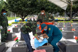 Tổ công tác khai quật, lấy mẫu hài cốt liệt sĩ tại Nghĩa trang Liệt sĩ Đức Cơ (xã Đức Cơ, tỉnh Gia Lai). (Ảnh: Hoài Nam/TTXVN)