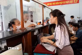 Cán bộ Trung tâm phục vụ hành chính công xã Hoàn Lão (tỉnh Quảng Trị) giải đáp các thắc mắc cho người dân trong giải quyết thủ tục hành chính. (Ảnh: Tá Chuyên/TTXVN)