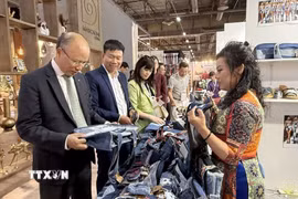 Đại sứ đặc mệnh toàn quyền Việt Nam tại Pháp Đinh Toàn Thắng tham quan gian hàng của doanh nghiệp Việt Nam. (Ảnh: Hữu Chiến/TTXVN)