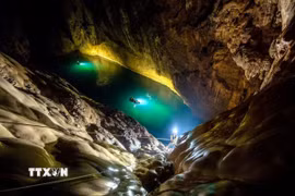 Du khách chinh phục, leo lên Bức tường Việt Nam cao 90m trong Tour khám phá du lịch mạo hiểm hang Sơn Đoòng. (Ảnh: TTXVN phát)