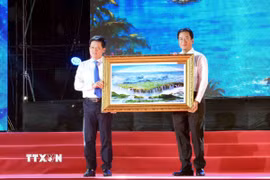 Phó Chủ tịch Thường trực UBND tỉnh Khánh Hòa Nguyễn Long Biên (bên phải) tặng quà lưu niệm đến lãnh đạo UBND tỉnh Quảng Trị. (Ảnh: Tá Chuyên/TTXVN)