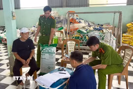 Đối tượng Hứa Văn Chọn (áo đen) làm việc với lực lượng chức năng. (Ảnh: TTXVN phát)